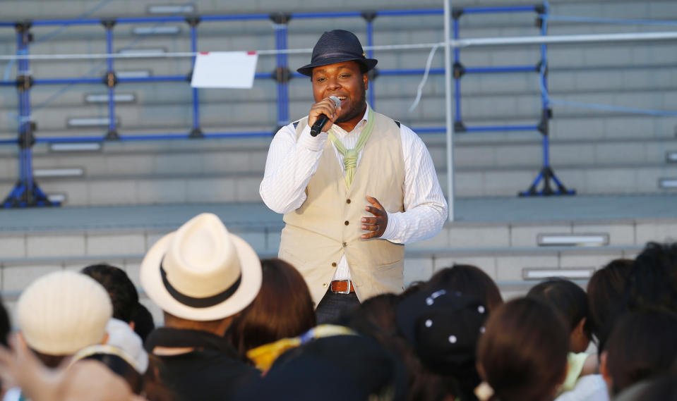 In this photo taken Monday, Aug. 5, 2013, San Francisco-born Chris Hart sings before his fans at an outdoor concert in Tokyo. His album of cover versions of Japanese pop tunes is rising on the charts. And the crooner, a past winner of the Japanese karaoke show "Nodojiman The! World," is scoring on this nation's equivalent of “American Idol,” being billed as a genius who understands the “soul” of Japan. (AP Photo/Koji Sasahara)