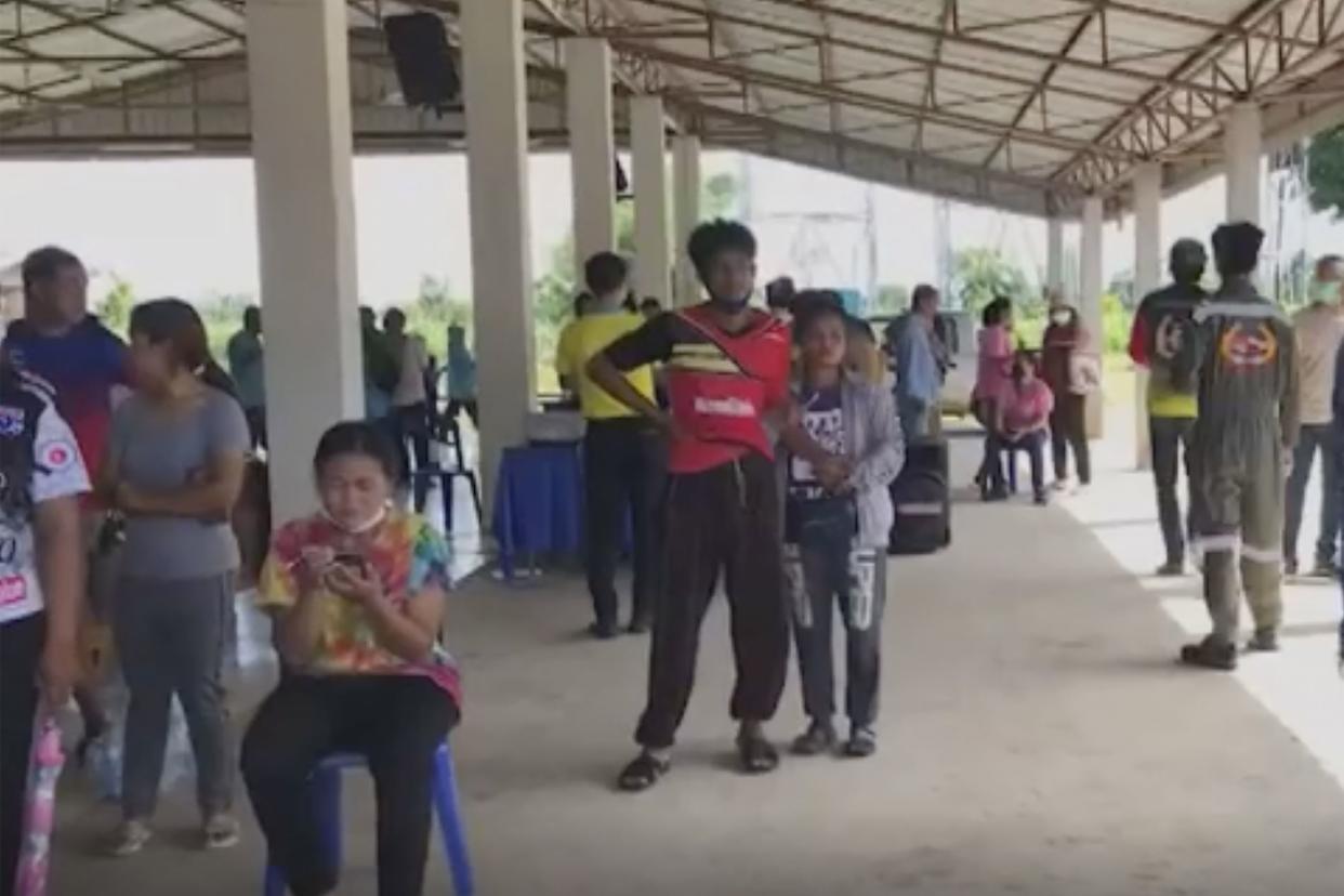 In this image taken from video, people gather outside the site of an attack at a daycare canter, Thursday, Oct. 6, 2022, in the town of Nongbua Lamphu, northeastern Thailand. More than 30 people, primarily children, were killed Thursday when a gunman opened fire in the childcare center, authorities said.