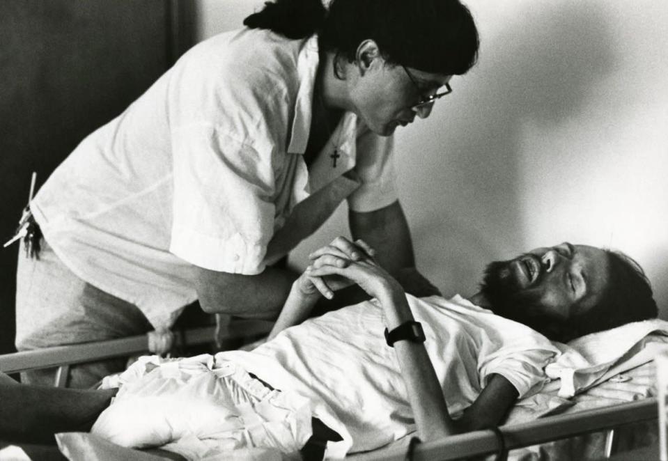 Peta, a volunteer at Pater Noster House in Ohio, cares for a dying David Kirby, 1990. (© Therese Frare) <br> <br> <a href="http://life.time.com/history/behind-the-picture-the-photo-that-changed-the-face-of-aids/#1" rel="nofollow noopener" target="_blank" data-ylk="slk:Click here to see the full collection at LIFE.com;elm:context_link;itc:0;sec:content-canvas" class="link ">Click here to see the full collection at LIFE.com</a>