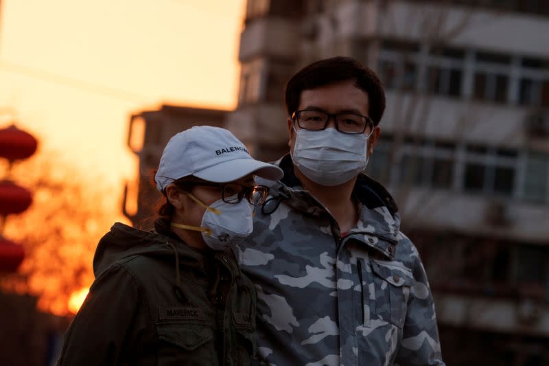 People wear face masks in a street in Beijing as the country is hit by an outbreak of the novel coronavirus