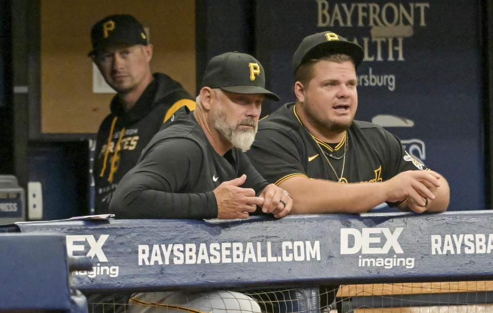 Pittsburgh Pirates manager Derek Shelton, front left, talks with Daniel Vogelbach in the dugout during the first inning of a baseball game against the Tampa Bay Rays, Sunday, June 26, 2022, in St. Petersburg, Fla. (AP Photo/Steve Nesius)
