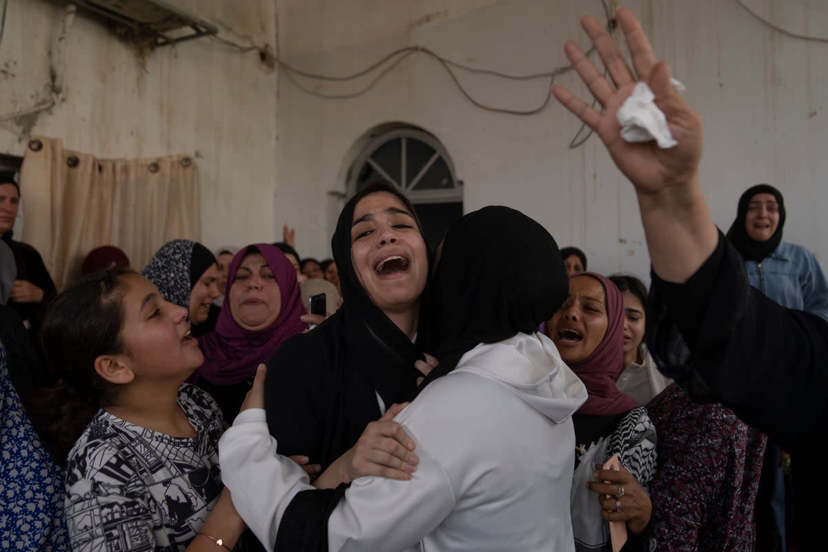 Palestinian mourners cry after taking the last look at the body of Mohammad Balhan, 15, during his funeral in the West Bank refugee camp of Aqabat Jaber, Jericho (AP)