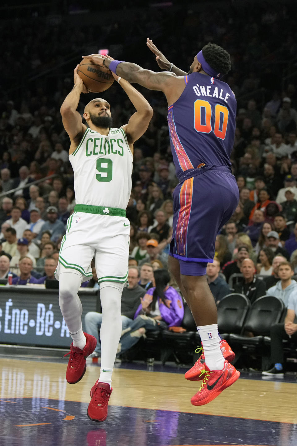 Phoenix Suns forward Royce O'Neale (00) pressures Boston Celtics guard Derrick White (9) during the first half of an NBA basketball game, Saturday, March 9, 2024, in Phoenix. (AP Photo/Rick Scuteri)