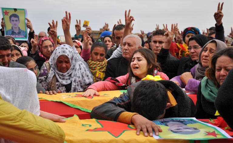 Families of fighters from the People's Protection Units (YPG) attend a funeral in Syria's northeasten city of Qamishli on February 28, 2015 for three fighters killed during clashes with Islamic State jihadists
