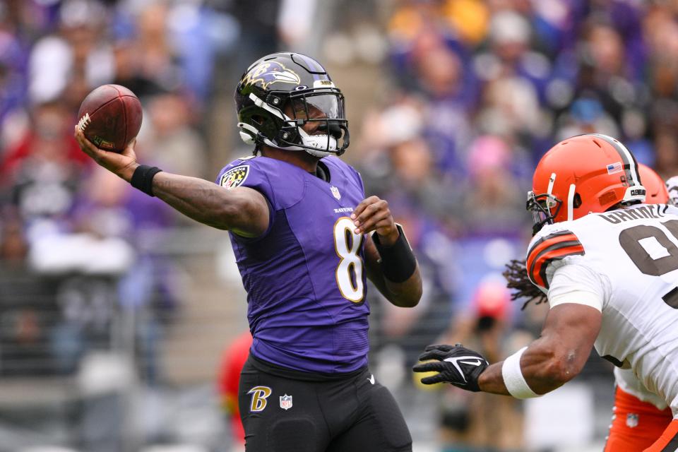 Baltimore Ravens quarterback Lamar Jackson (8) throws under pressure from Browns defensive end Myles Garrett (95) in the first half Oct. 23, 2022, in Baltimore.