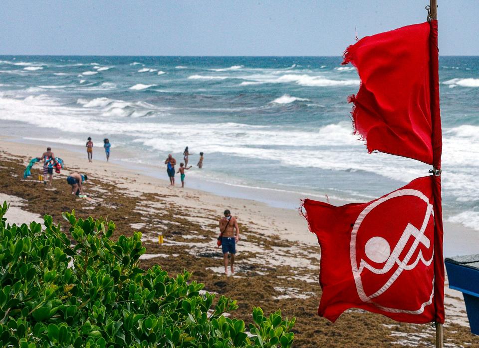 Red no swimming flags fly at Lantana Municipal Beach as Isaias approaches the Florida coast Saturday.