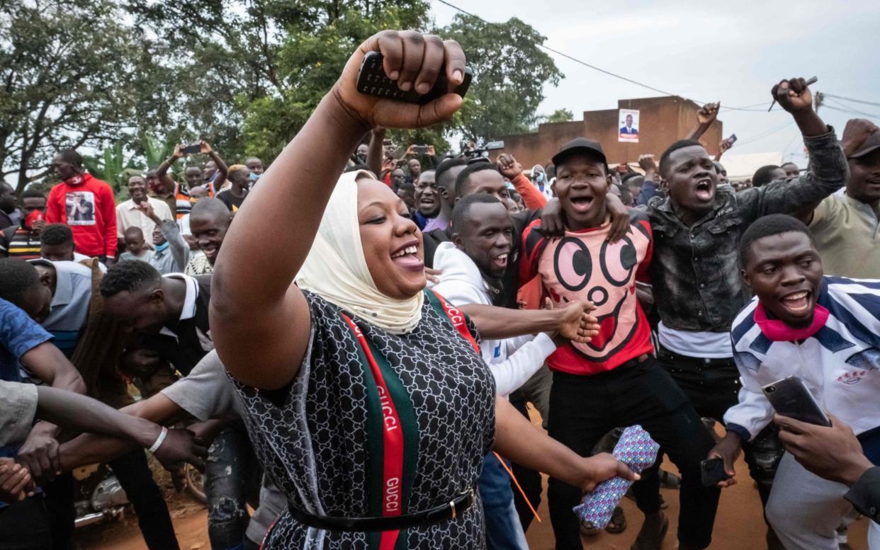 Supporters react to the arrival of musician-turned-politician Robert Kyagulanyi also known as Bobi Wine, at a polling station in Magere, Uganda - Yasuyoshi Chiba/AFP