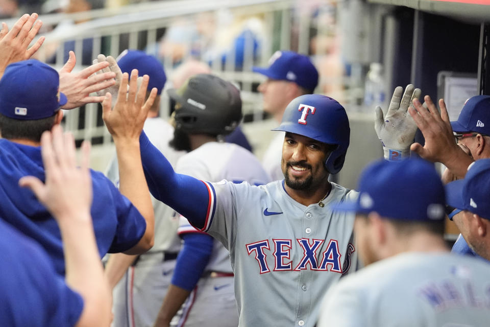 Texas Rangers' Marcus Semien celebrates with teammates in the dugout after hitting a solo home run in the frist inning of a baseball game against the Atlanta Braves Friday, April 19, 2024, in Atlanta. (AP Photo/John Bazemore)