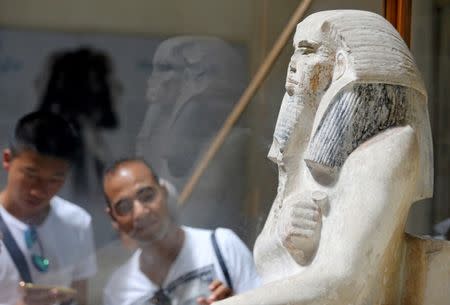 Tourists look at pharaonic artefact inside the Egyptian Museum during the summer season in Cairo, Egypt, July 14, 2016. REUTERS/Mohamed Abd El Ghany