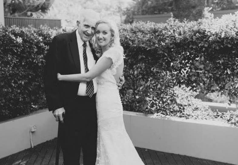 Queensland woman Sian is shown on her wedding day posing in a garden with her grandfather.