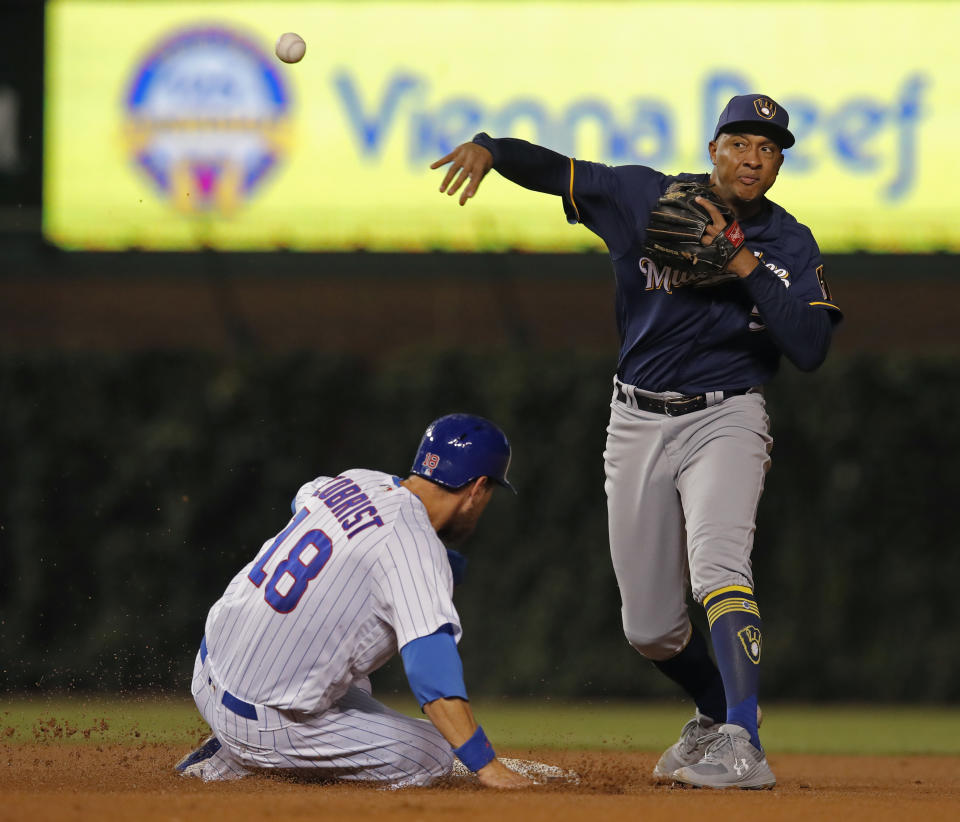 Milwaukee Brewers' Jonathan Schoop, right, makes a throw to first base as Chicago Cubs' Ben Zobrist is out at second base during the fourth inning of a baseball game Monday, Sept. 10, 2018, in Chicago. (AP Photo/Jim Young)