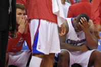 Los Angeles Clippers' Blake Griffin, left, looks on from the bench as Glen Davis rubs his head during the second half in Game 1 of an opening-round NBA basketball playoff series, Saturday, April 19, 2014, in Los Angeles. The Warriors won 109-105. (AP Photo/Mark J. Terrill)