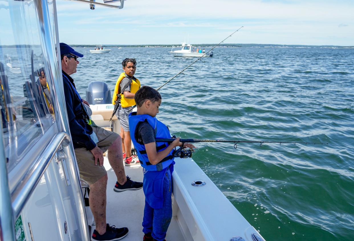 Fishing campers Kaiden King, center, of Providence and Nicolas Di Carlo-Mustard of East Greenwich get some guidance from Capt. Dave Monti.