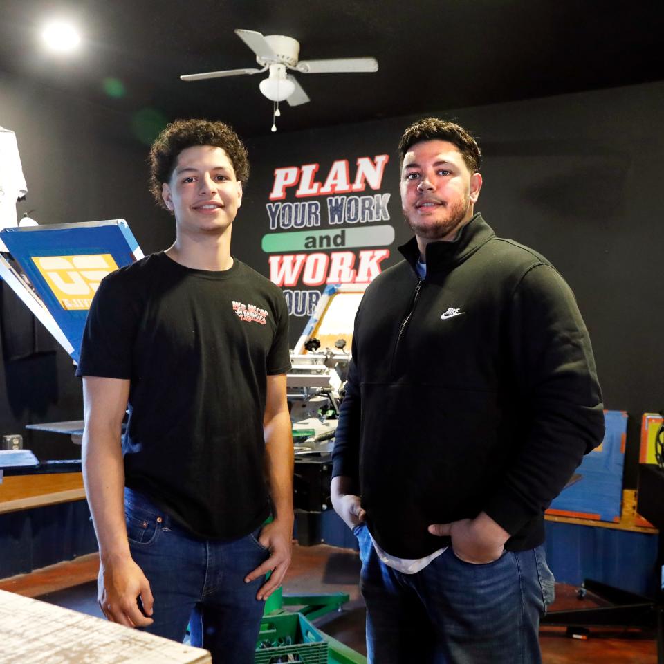 Caleb Smith, left, and Anthony Smith stand in front of a shirt press at their workshop on Wheeling Avenue in Zanesville. The brothers and lifelong Zanesville residents started We Wrap Graphics in 2021 and have performed multiple projects in the area, including security upgrades at Zanesville City Schools.