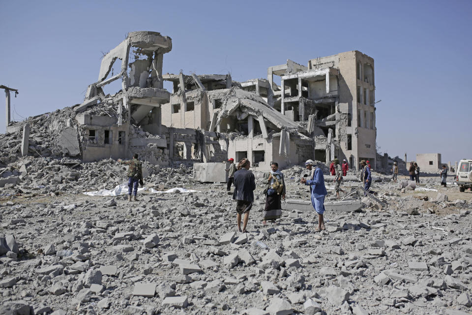 Bodies covered in plastic lie on the ground amid the rubble of a Houthi detention center destroyed by Saudi-led airstrikes, that killed at least 60 people and wounding several dozen according to officials and the rebels' health ministry, in Dhamar province, southwestern Yemen, Sunday, Sept. 1, 2019. The officials said the airstrikes took place Sunday and targeted a college in the city of Dhamar, which the Houthi rebels use as a detention center. The Saudi-led coalition said it had hit a Houthi military facility used as storages for drones and missiles in Dhamar. (AP Photo/Hani Mohammed)