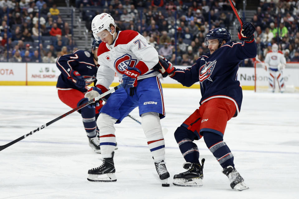 Montreal Canadiens forward Jake Evans, left, works for the puck in front of Columbus Blue Jackets forward Justin Danforth during the first period of an NHL hockey game in Columbus, Ohio, Wednesday, Nov. 29, 2023. (AP Photo/Paul Vernon)