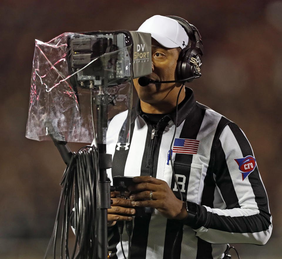 FILE - In this Nov. 3, 2018, file photo, referee Reggie Smith reviews a targeting penalty during the first half of an NCAA college football game in Lubbock, Texas. The NCAA Playing Rules Oversight Panel adjusted the targeting rule in college football, allowing video review officials to overturn calls if any element of the penalty cannot be confirmed. The adjustment to the rule announced Tuesday, April 23, 2019, means there will be no option for letting the call on the field "stand" during a targeting review. It must either be confirmed or overturned. (AP Photo/Brad Tollefson, File)