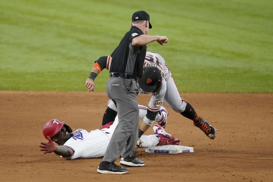 Texas Rangers' Adolis Garcia calls for time, San Francisco Giants' Brandon Crawford keeps the tag on and umpire Lance Barksdale calls Garcia out in the ninth inning of a baseball game in Arlington, Texas, Wednesday, June 9, 2021. The play was upheld after a video review. (AP Photo/Tony Gutierrez)