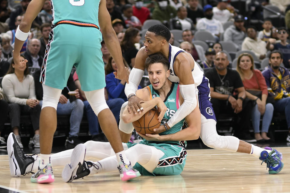 San Antonio Spurs' Zach Collins, front, and Los Angeles Lakers' Russell Westbrook fight for possession during the second half of an NBA basketball game, Friday, Nov. 25, 2022, in San Antonio. (AP Photo/Darren Abate)