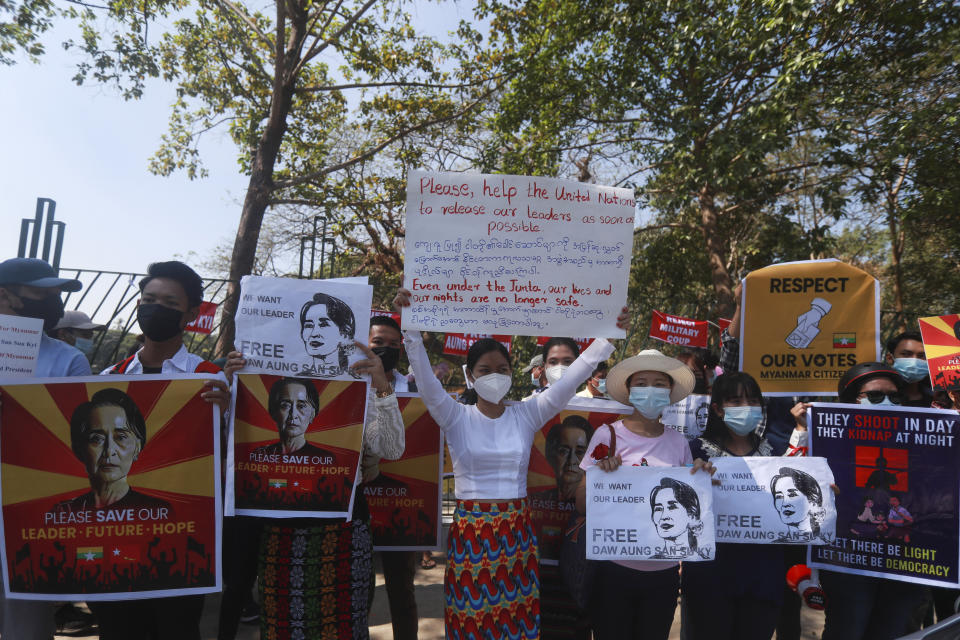 Anti-coup protesters hold posters with images of deposed Myanmar leader Aung San Suu Kyi as they gather outside the U.N. Information Office in Yangon, Myanmar, Sunday, Feb. 14, 2021. Vast numbers of people all over Myanmar have flouted orders against demonstrations to march again in protest against the military takeover that ousted the elected government of Suu Kyi. (AP Photo)