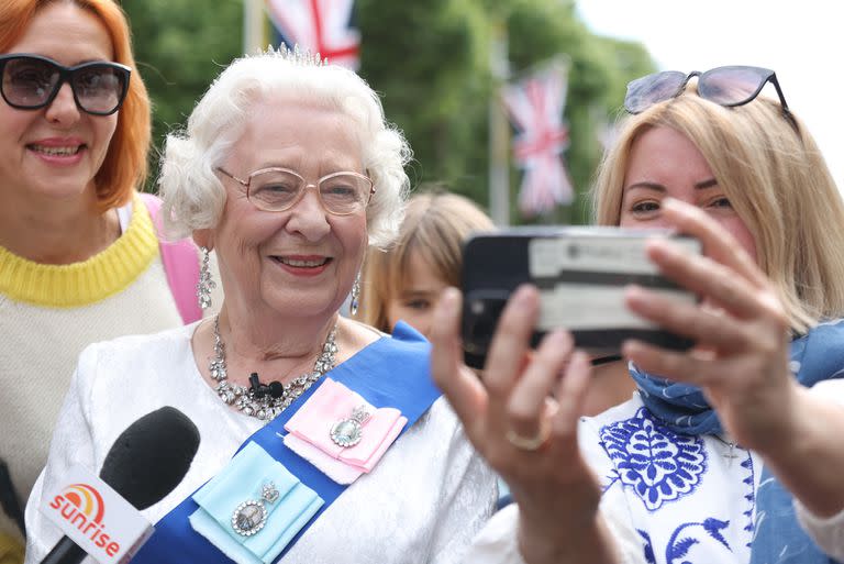 Selfie con una mujer vestida de Reina Isabel II en las cercanías del Palacio de Buckingham, el 1 de junio de 2022