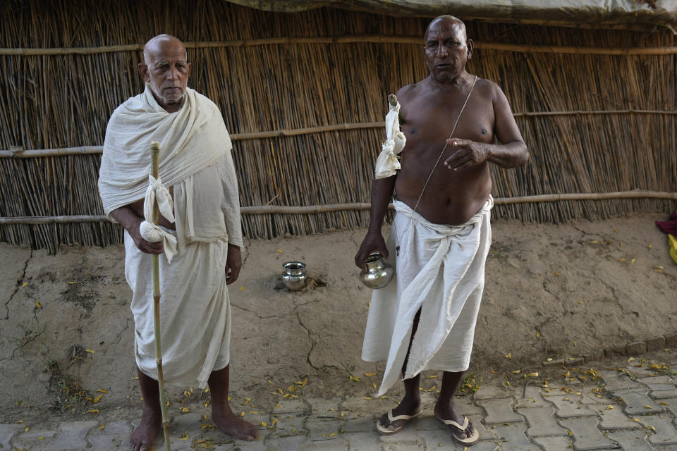 Shyam Lal Rai, left, and Ramayan Rai return after performing last rites to their respective wife who died of intense heat wave in Ballia district, Uttar Pradesh state, India, Monday, June 19, 2023. Several people have died in two of India's most populous states in recent days amid a searing heat wave, as hospitals find themselves overwhelmed with patients. More than hundred people in the Uttar Pradesh state, and dozens in neighboring Bihar state have died due to heat-related illness. (AP Photo/Rajesh Kumar Singh)
