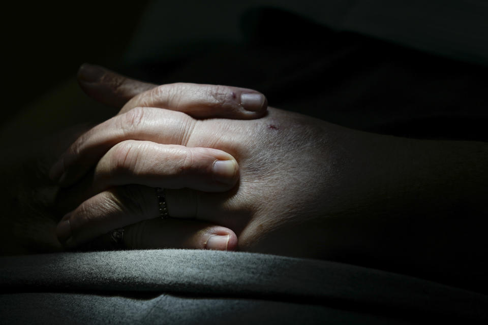 Cindy Clemons clasps her hands during a dental treatment at Meharry Medical College School of Dentistry, Tuesday, Sept. 12, 2023, in Nashville, Tenn. Clemons was able to receive care after an expansion of the state's Medicaid program. (AP Photo/George Walker IV)