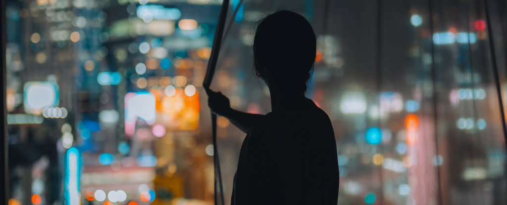 person pulling curtains closed on a city