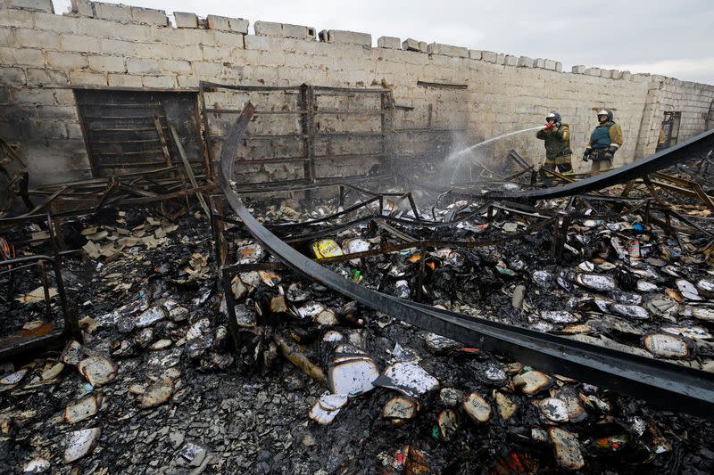 Los bomberos trabajan en un mercado local afectado por bombardeos durante el conflicto entre Rusia y Ucrania en Donetsk, Ucrania controlada por Rusia