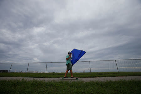 A man uses a kayak sail to propel himself on his skateboard ahead of the arrival of Hurricane Irma in Tampa, Florida, U.S., September 9, 2017. REUTERS/Chris Wattie