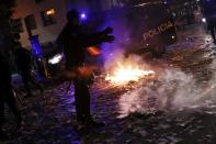 Policemen walk next to a fire during a protest in Madrid November 4, 2013. Spain's labor unions called for an indefinite strike from Tuesday in Spain's capital for the street cleaning and park maintenance sectors in protest against announced layoffs that could affect around a thousand municipal workers, according to local media. (REUTERS/Juan Medina)