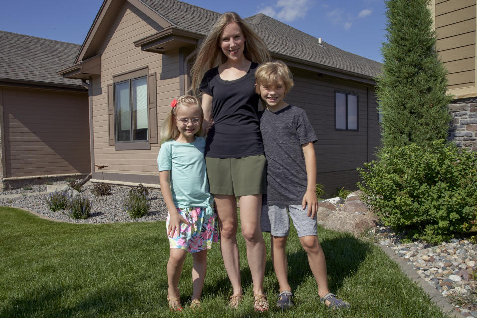 Tara Carlson poses for a photo with her children Kyler, 9, and Alayna, 6, outside their home in Omaha, Neb., Tuesday, July 7, 2020. Carlson pulled her kids out of summer camp at the last minute, losing $300 in deposits. (AP Photo/Nati Harnik)