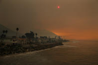 <p>Homes stand along the beach as the sun is visible through thick smoke from a wildfire Wednesday, Dec. 6, 2017, in Ventura, Calif. (Photo: Jae C. Hong/AP) </p>