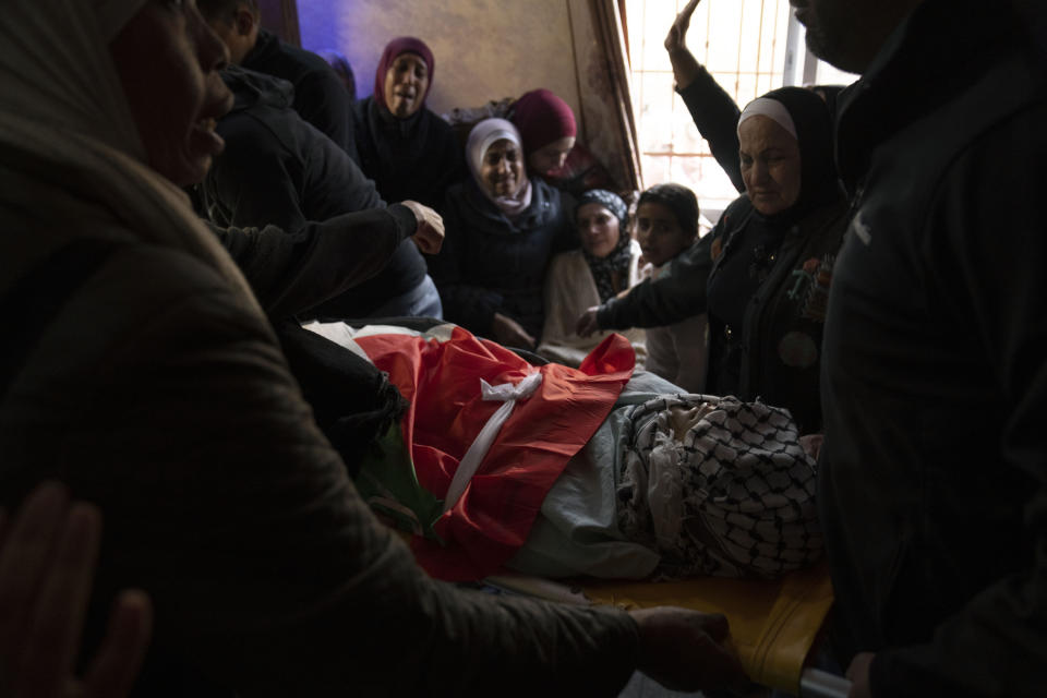 Mourners take the last look at the body of Mahmoud Al-Aydi, 17 during his funeral in the West Bank refugee camp of Faraa, near Jenin, Tuesday, Feb. 14, 2023. Al-Aydi was killed early Tuesday during an Israeli army raid in a refugee camp in the northern West Bank, Palestinian officials said. (AP Photo/Nasser Nasser)