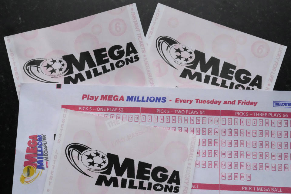 Mega Millions lottery tickets and a wager slip are displayed, Friday, Jan. 6, 2023, in Derry, N.H. Twenty-three consecutive drawings later with no grand prize winner named, the Mega Millions jackpot is now flirting with nearly $1 billion, making it one of the largest jackpots in lottery history. (AP Photo/Charles Krupa)