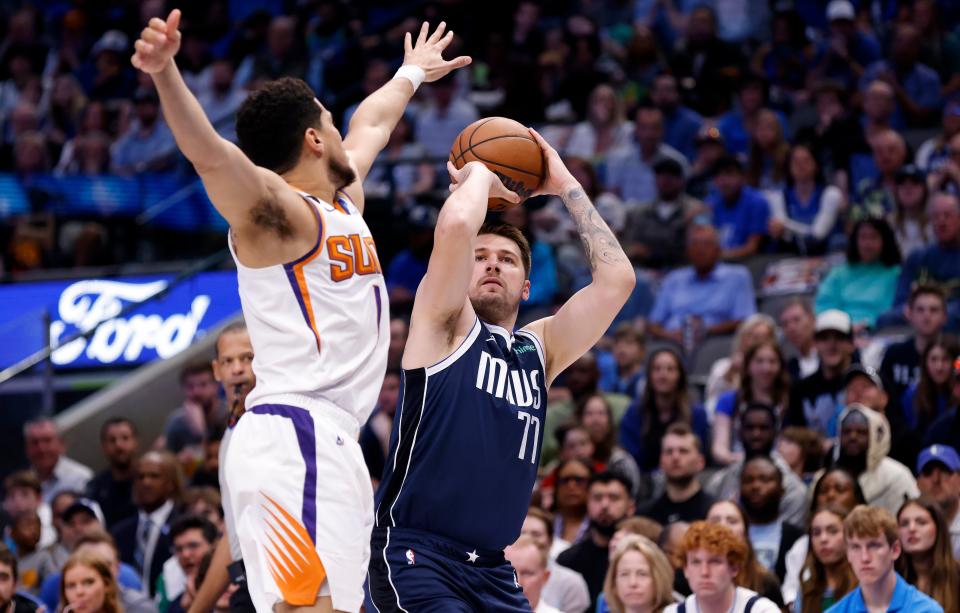 Luka Doncic (77) of the Dallas Mavericks shoots the ball as Devin Booker (1) of the Phoenix Suns defends in the first half of the game at American Airlines Center on March 5, 2023, in Dallas, Texas.