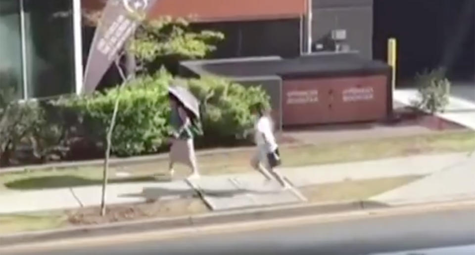 One woman can be seen walking out the front of the Southport RSL when the other sneaks up behind her. Source: 7 News