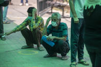 People wait for their turn to be tested for COVID-19 at a government hospital in Noida, a suburb of New Delhi, India, Thursday, April 15, 2021. India reported more than 200,000 new coronavirus cases Thursday, skyrocketing past 14 million overall as an intensifying outbreak puts a grim weight on its fragile health care system. (AP Photo/Altaf Qadri)