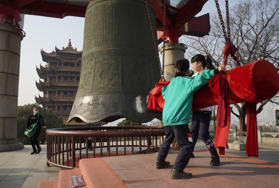 Los niños juegan con una campana. Una escena que hace un año era completamente impensable. (AP Photo/Ng Han Guan)