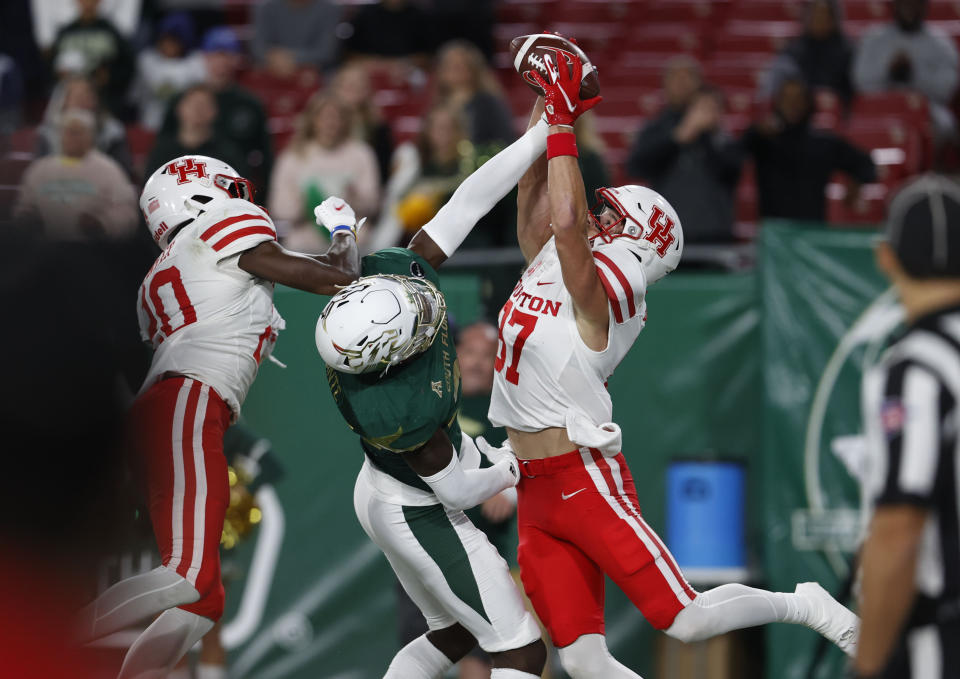 Houston wide receiver Jake Herslow, right, pulls in a touchdown pass in front of South Florida's Mekhi LaPointe, center during the first half of an NCAA college football game Saturday, Nov. 6, 2021, in Tampa, Fla. (AP Photo/Scott Audette)