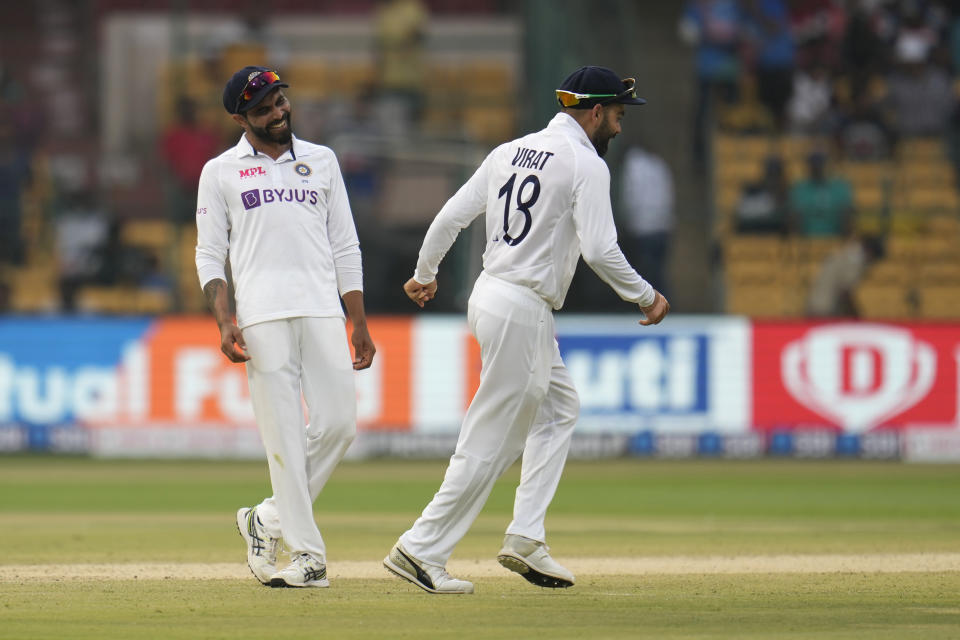 India's Virat Kohli, right, and Ravindra Jadeja share a light moment during the third day of the second cricket test match between India and Sri Lanka in Bengaluru, India, Monday, March 14, 2022. (AP Photo/Aijaz Rahi)