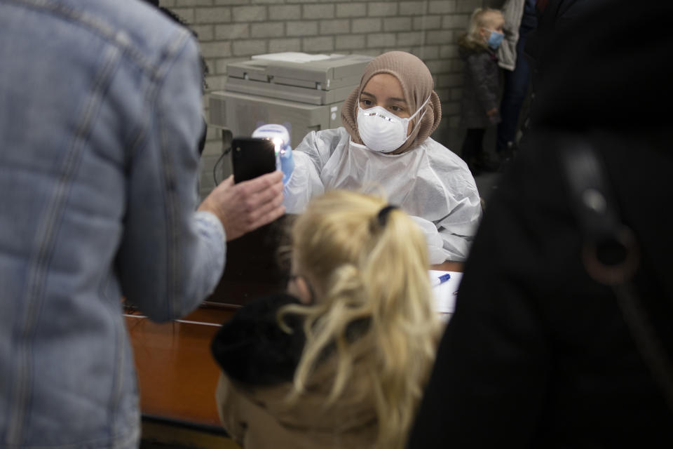 Residents of Bergschenhoek, Netherlands, register as they take part in a mass test of all of the municipality's 62,000 residents starting Wednesday, Jan. 13, 2021, following a cluster of COVID-19 cases at an elementary school, including about 30 cases of the British coronavirus variant. (AP Photo/Peter Dejong)