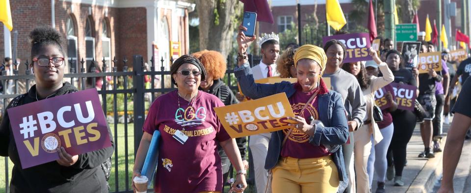 Bethune-Cookman University students march along Mary McLeod Bethune Boulevard on Wednesday from the B-CU campus to the Midtown Cultural & Educational Center to participate in early voting. "Seeing everyone out here, it’s a beautiful thing to see,” said David Bartee, a B-CU senior who joined the march.  “Everyone chanting, holding signs, showing that our votes matter."