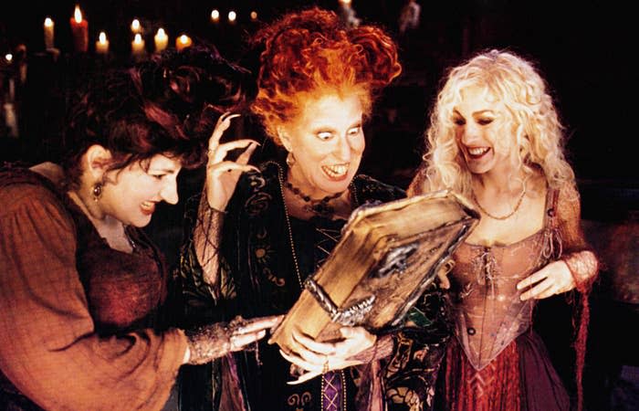 The Sanderson sisters looking at their magic book