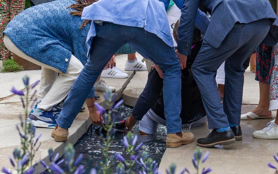 Chelsea Flower Show visitors help a woman who fell into the water feature at the BBC Studios garden - Vagner Vidal/Hyde News & Pictures Ltd