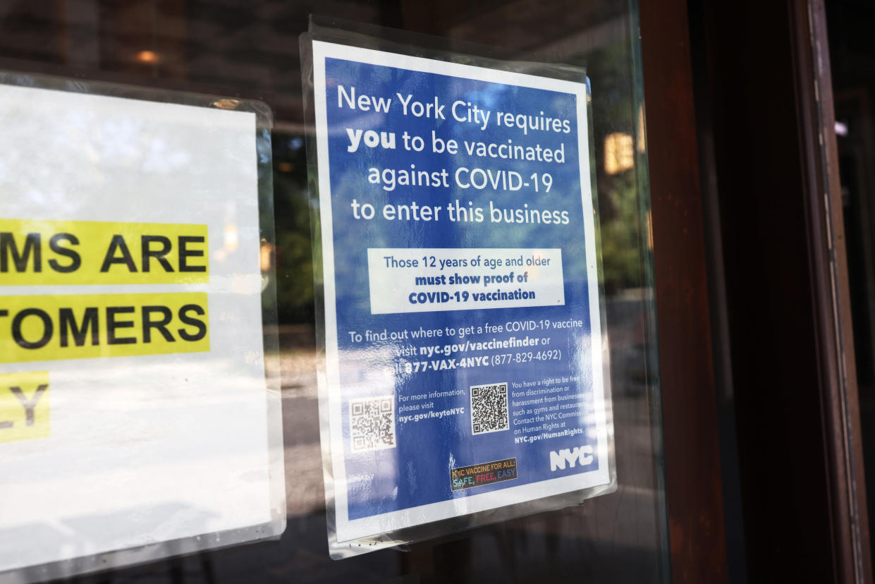 A sign warning that theatergoers must be vaccinated is posted at the entrance of Nighthawk Cinema on Wednesday in Brooklyn, N.Y.