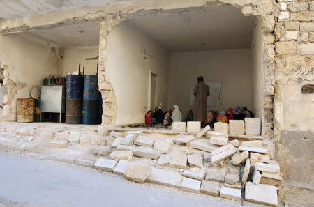 A man gives a Koran class inside a damaged house in Tariq al-Bab neighbourhood of Aleppo, Syria November 2, 2016. REUTERS/Abdalrhman Ismail