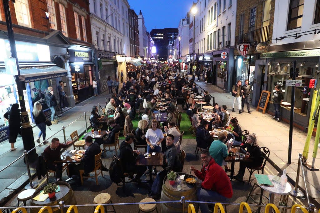 People eating on restaurant tables placed outside on Old Compton St in Soho, in 2020   (Yui Mok/PA Wire)