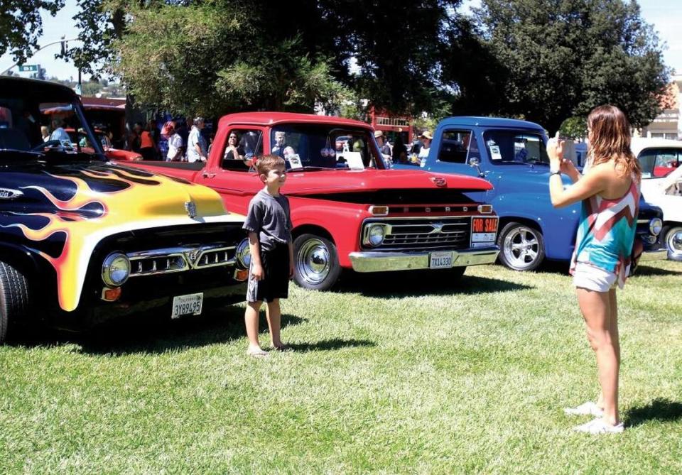 Danielle Salazar of Paso Robles, takes a photo of her son, Justic Romo, 7, in front of some classic trucks in 2015. Paso Robles Classic Car Weekend features a cruise on Friday and a classic car show on Saturday.