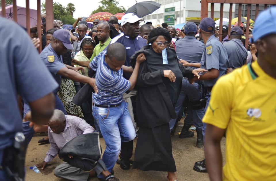 A mourner falls in a stampede as others run to queue before boarding buses to take them to the Union Buildings in Pretoria